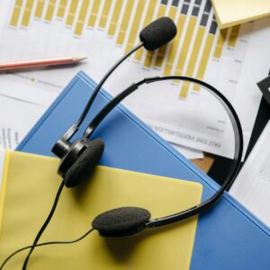 Close-up of an office desk with headset, charts, and documents showcasing customer service support.